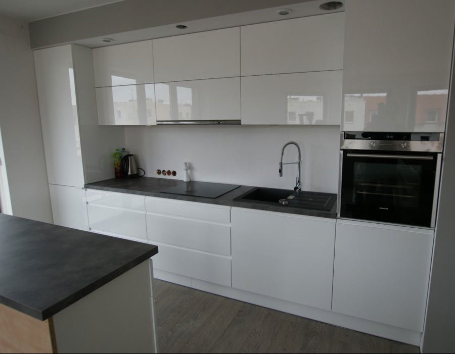 Nowoczesna, minimalistyczna kuchnia: białe, lakierowane fronty, ciemny blat, wyspa kuchenna z ciemnym blatem, zabudowany piekarnik Siemens.