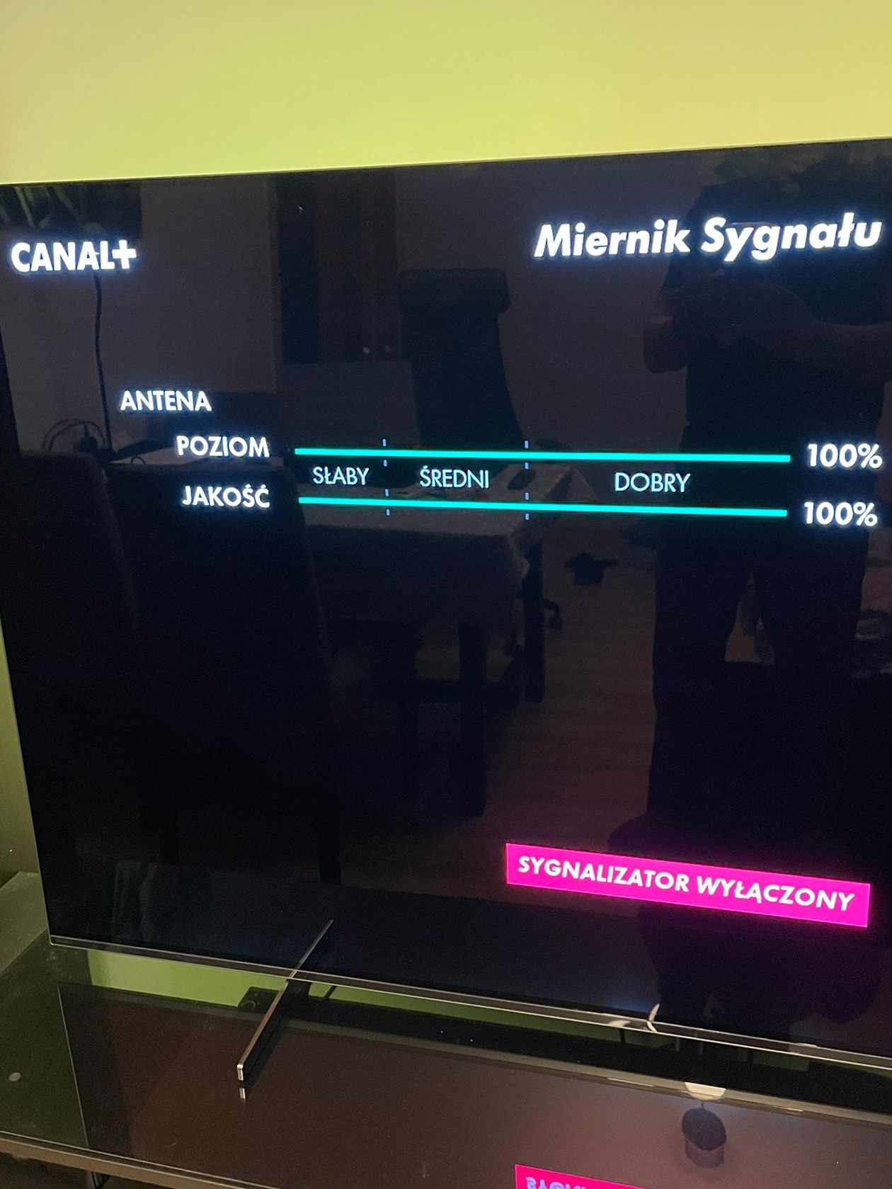 Ekran telewizora z włączonym miernikiem sygnału antenowego Canal+, wskazującym 100% poziom i jakość sygnału.
