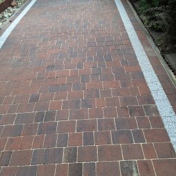 TK Clean Krzysztof Tkocz - Czysta, brązowo-grafitowa kostka brukowa ułożona w regularny wzór, obramowana pasem jasnego grysu. Widok z góry, podkreślający geometrię i porządek nawierzchni.