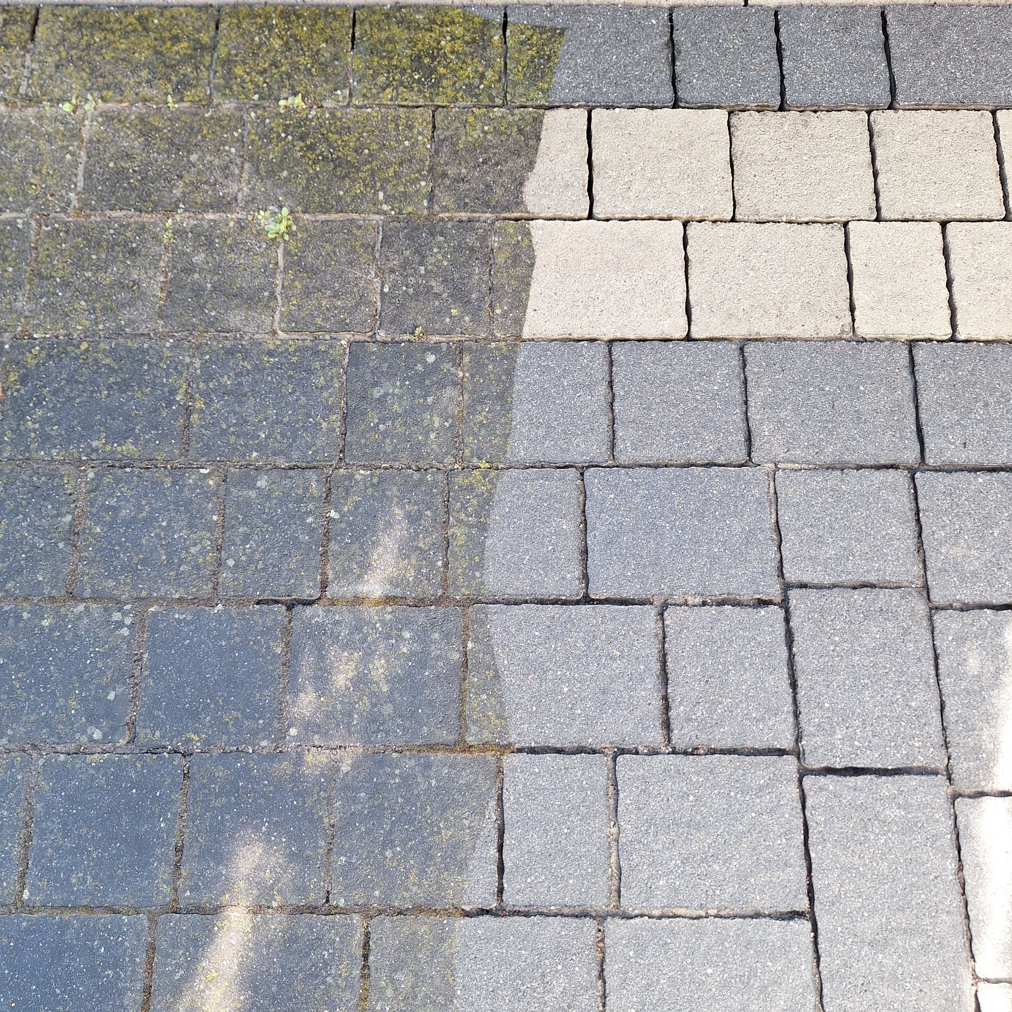 Efekt mycia kostki brukowej w Jankowicach Rybnickich: widoczna różnica między zabrudzoną, porośniętą mchem a czystą powierzchnią kostki. Porównanie przed i po.