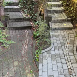 Kostka brukowa przed i po czyszczeniu, schody i ścieżka z wyraźną różnicą w kolorze, zarośnięta roślinnością. Efekt czyszczenia kostki brukowej.
