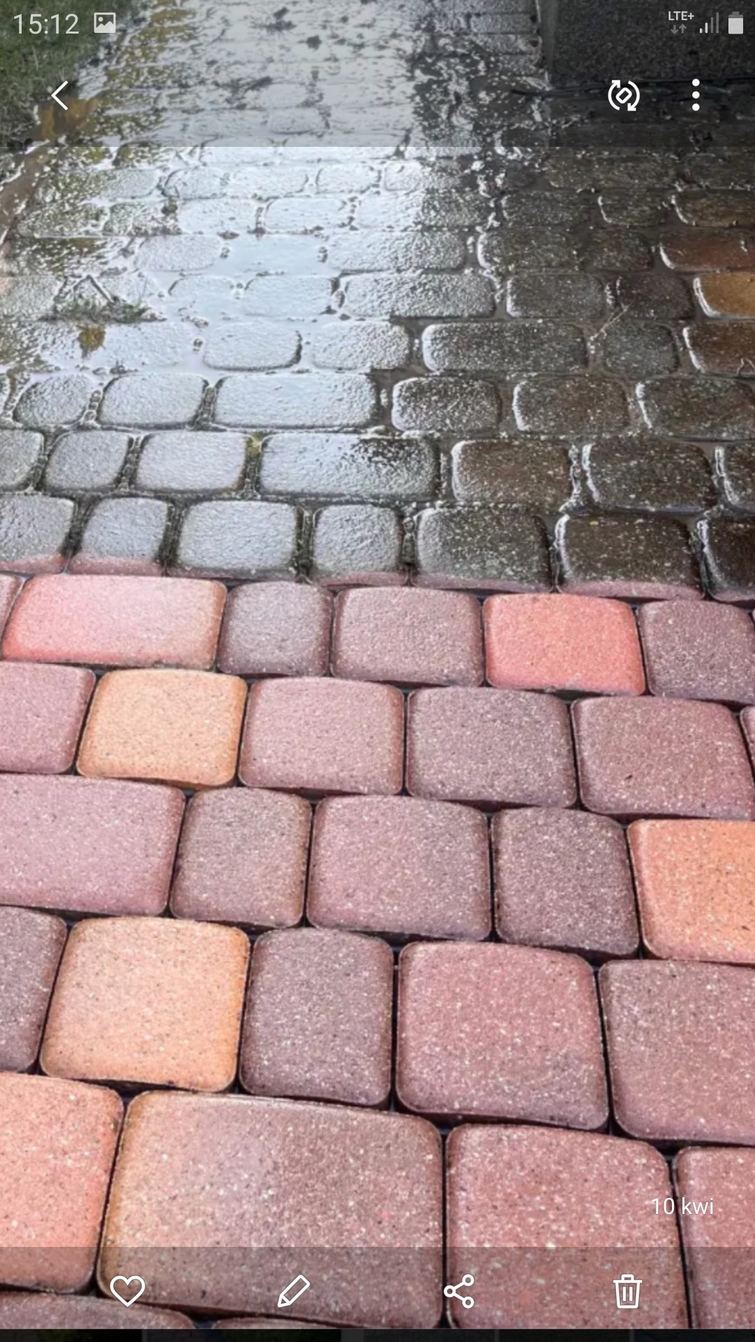 Częściowo umyta kostka brukowa w odcieniach czerwieni i szarości, widoczny kontrast między czystą i brudną powierzchnią.