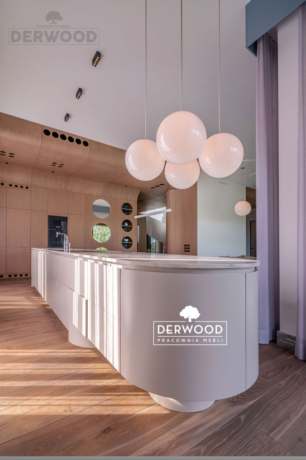 Nowoczesna kuchnia z wyspą o zaokrąglonym kształcie, wykończona w jasnych odcieniach drewna i bieli, oświetlona kulistymi lampami wiszącymi i promieniami słonecznymi padającymi na drewnianą podłogę...