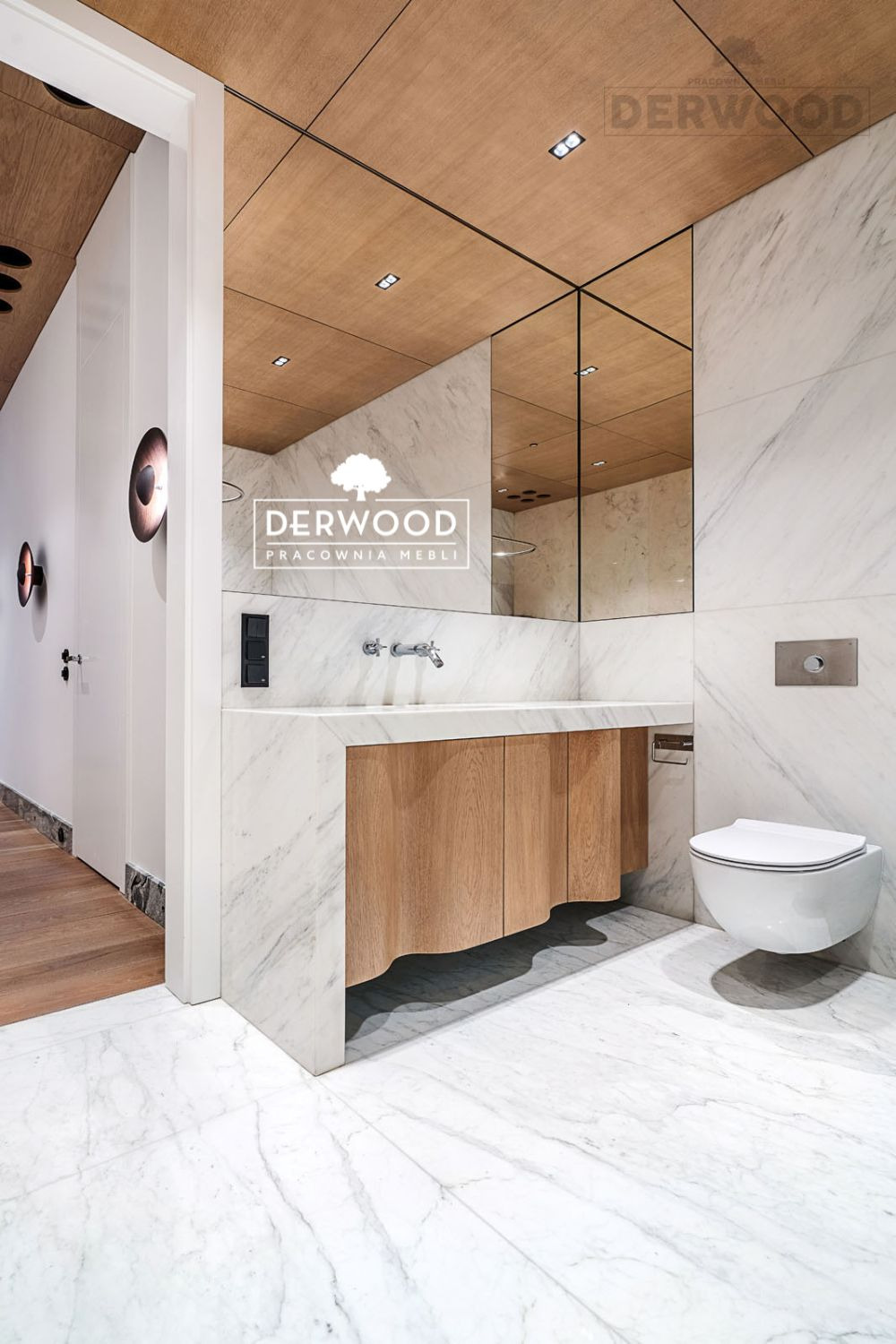 Nowoczesna łazienka z marmurowymi ścianami i podłogą, drewnianą szafką pod umywalką o falistym wykończeniu i podwieszaną toaletą.