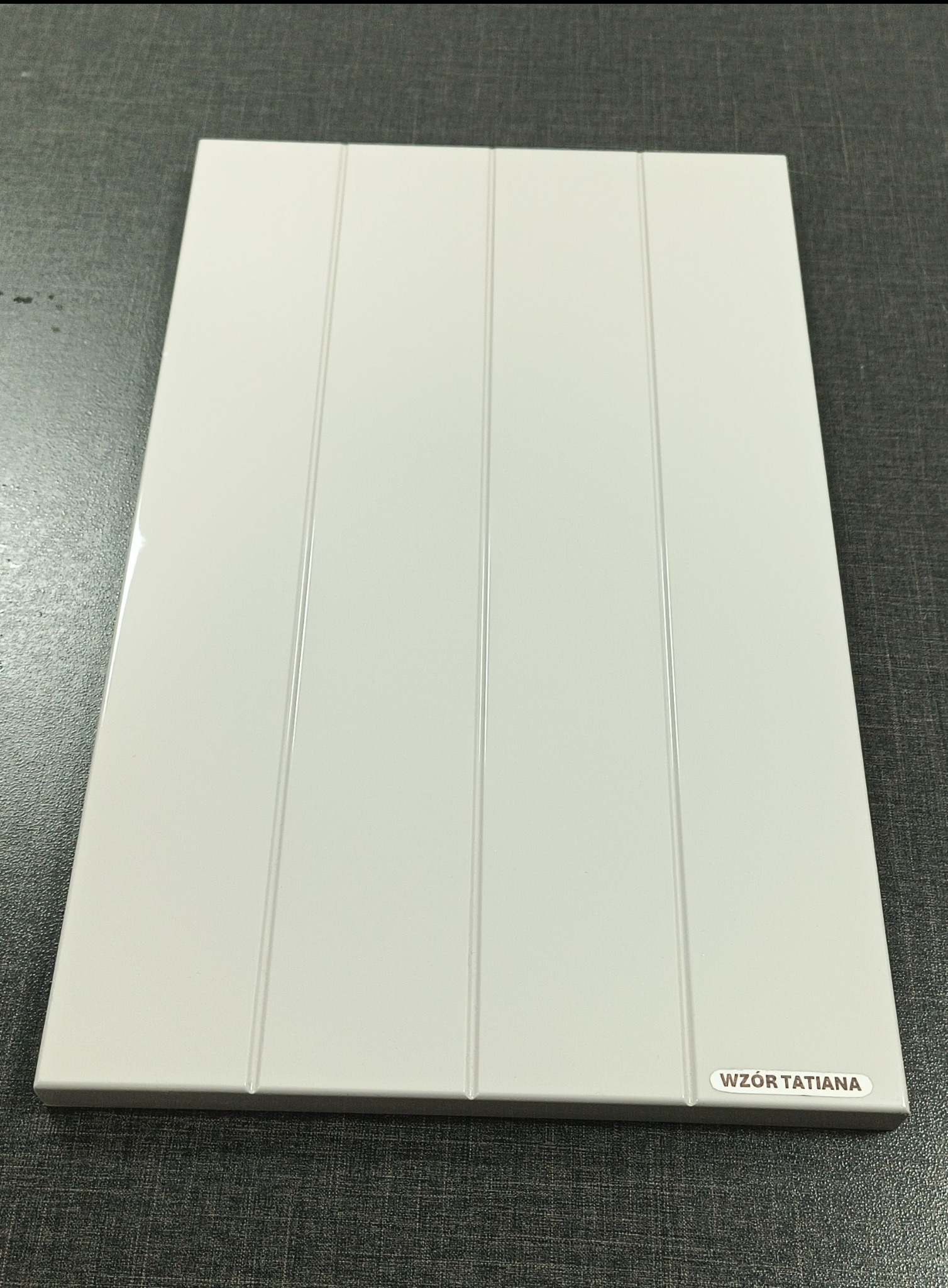Biały panel z czterema pionowymi wgłębieniami, oznaczony napisem 'WZÓR TATIANA' w prawym dolnym rogu, leżący na ciemnoszarym blacie.