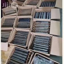 Stosy smartfonów ułożonych w kartonowych pudełkach, widoczne z góry, sugerujące przygotowanie do wysyłki lub magazynowanie.