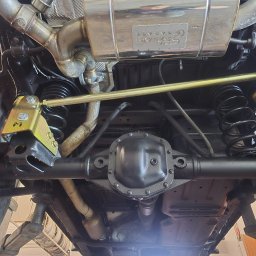 AGAW Patryk Michalak - Podwozie samochodu na podnośniku z widocznym układem wydechowym, zawieszeniem i elementami konstrukcyjnymi po konserwacji. Detaliczny widok od dołu.