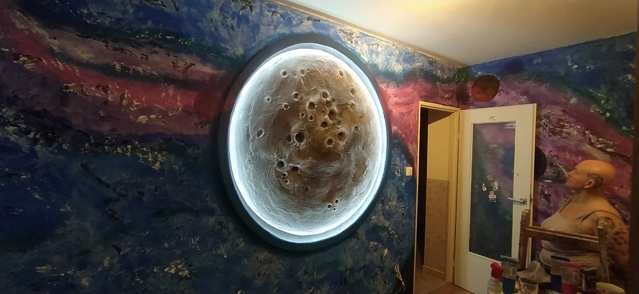 Artystyczna ściana z efektem kosmosu i trójwymiarowym, podświetlonym księżycem. Nietypowy wystrój wnętrza z ręcznie malowanymi detalami i unikalnym oświetleniem.