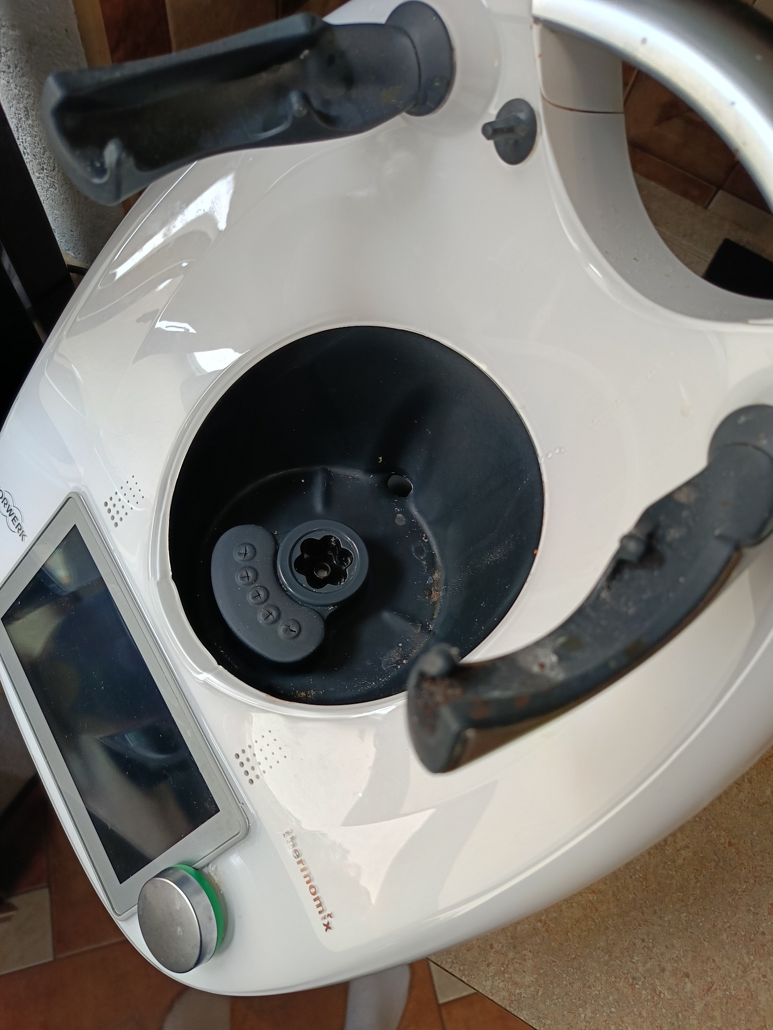 Wnętrze brudnego urządzenia Thermomix z widocznymi resztkami jedzenia. Perspektywa z góry ukazuje stopień zabrudzenia naczynia miksującego.