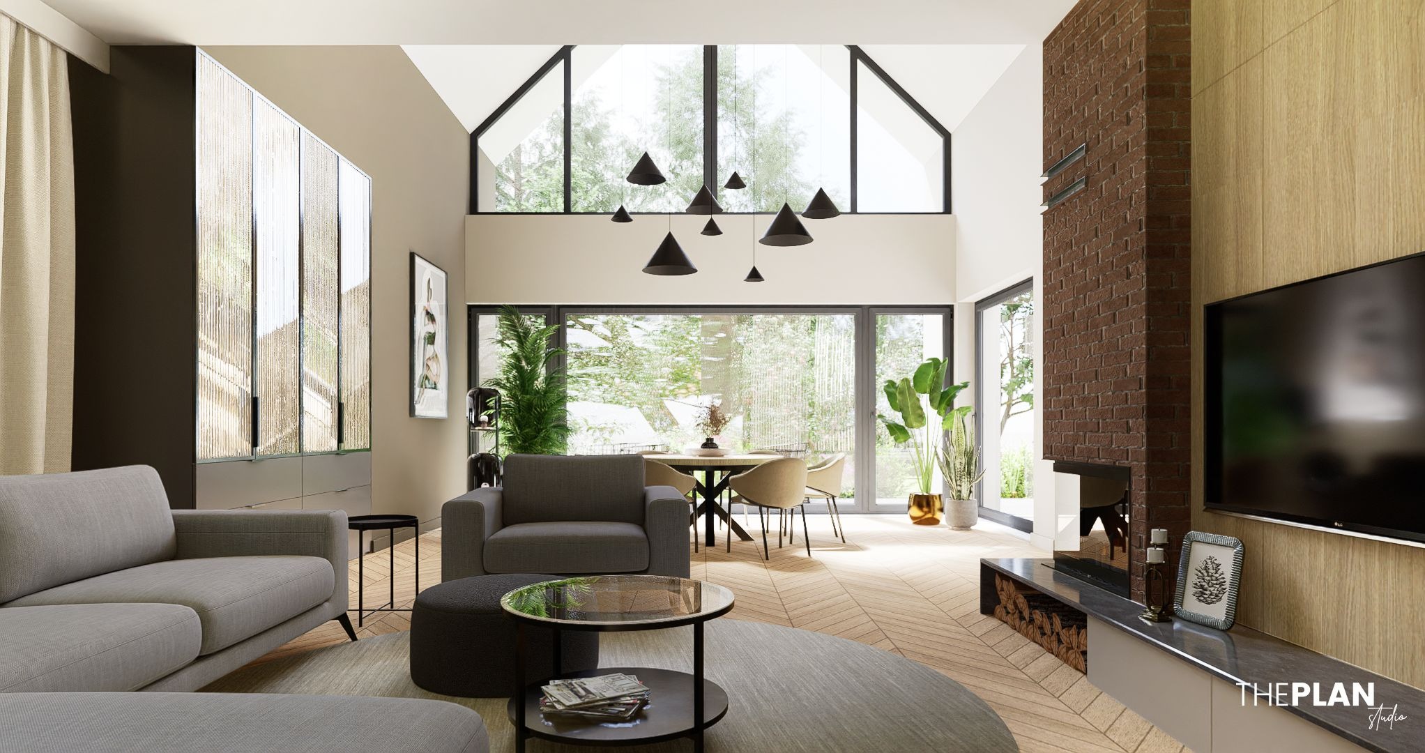 Jasne, przestronne wnętrze domu z wysokim oknem szczytowym i ceglanym kominkiem. Parkiet ułożony w jodełkę, szara sofa i okrągły dywan tworzą przytulną strefę relaksu.