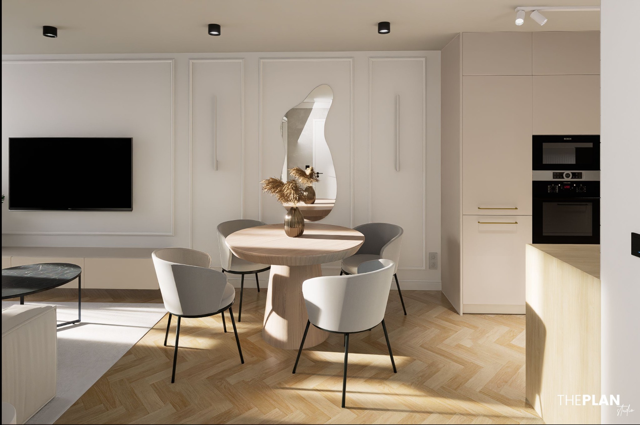 Jasne wnętrze: okrągły stół z krzesłami, asymetryczne lustro, telewizor i zabudowa kuchenna z piekarnikiem. Parkiet w jodełkę i listwy ścienne.
