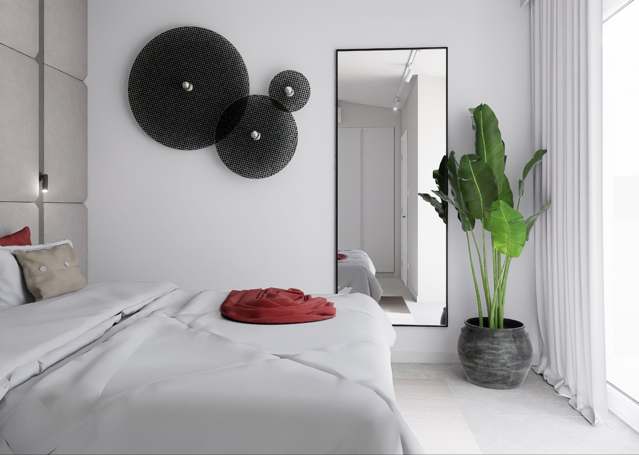 Nowoczesna sypialnia: biała pościel z czerwoną narzutą, okrągłe dekoracje ścienne, lustro odbijające wnętrze i roślina w szarej donicy przy oknie.