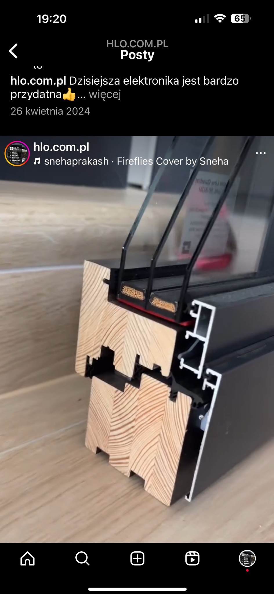 Przekrój ramy okiennej z drewna i aluminium, widoczne uszczelki i pakiety szybowe, na jasnej podłodze.