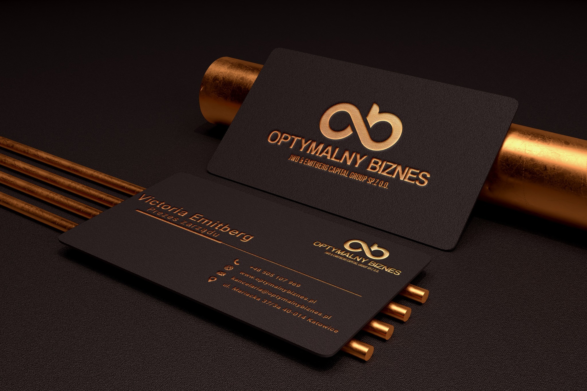 Eleganckie wizytówki firmy 'Optymalny Biznes' z logo w kolorze złota, na ciemnym tle z metalicznymi akcentami. Widoczny numer telefonu, adres e-mail i adres firmy.