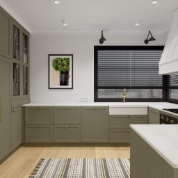 INTERIOR DESIGN Julia Jarząbkiewicz - Wizualizacja kuchni w odcieniach zieleni z białym blatem, okapem i dywanem w paski, oświetlona światłem punktowym i lampami ściennymi, z widokiem na okno z żaluzjami.