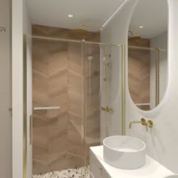 Wizualizacja łazienki z kabiną prysznicową ze złotymi detalami, drewnianą ścianą ułożoną w jodełkę, okrągłym lustrem z podświetleniem i umywalką nablatową.