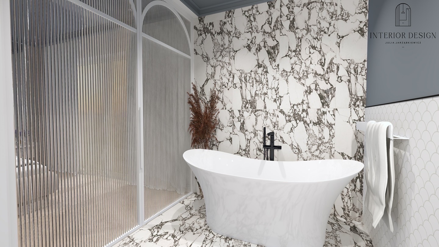 Elegancka łazienka z wolnostojącą białą wanną, czarną armaturą i ścianami wyłożonymi marmurowymi płytkami, oddzielona od strefy prysznicowej ścianką z pionowych listew. W tle widoczne logo firmy...