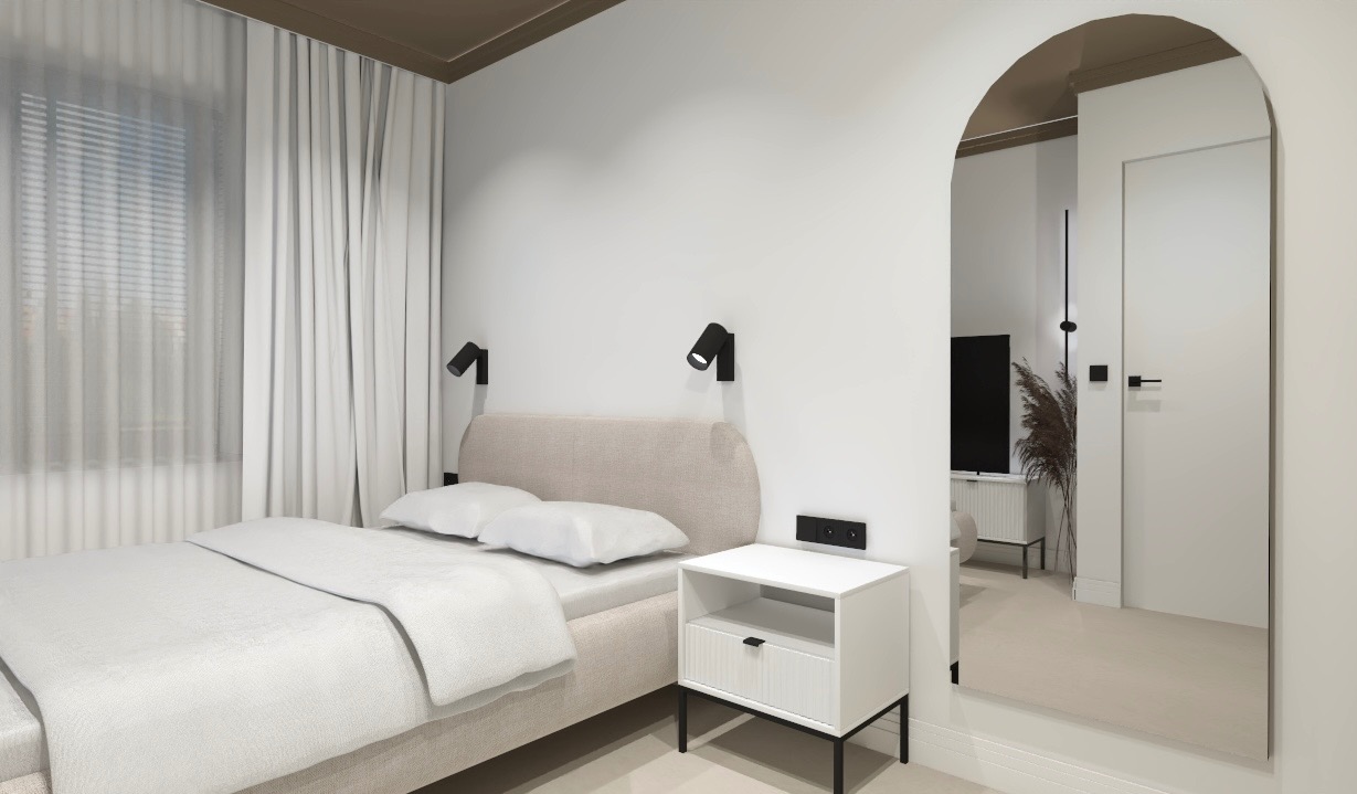 Jasna sypialnia z łóżkiem kontynentalnym, lampkami nocnymi na ścianie i szafką nocną z szufladą; widok przez łukowe przejście do dalszej części mieszkania.