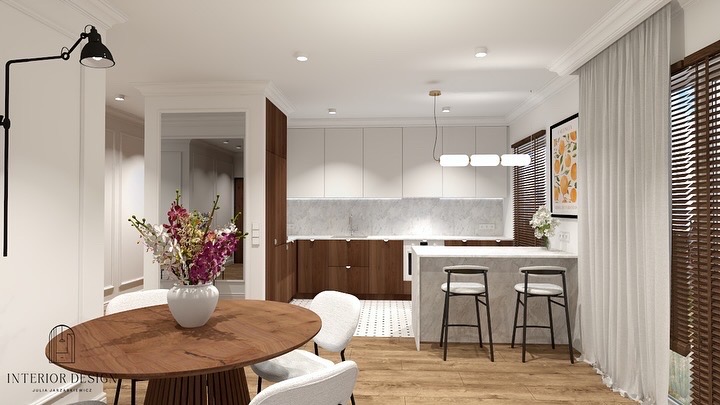 Elegancka kuchnia z drewnianymi i białymi szafkami, marmurowym blatem, okrągłym stołem z kwiatami i czarną lampą ścienną. Nowoczesny design wnętrza.