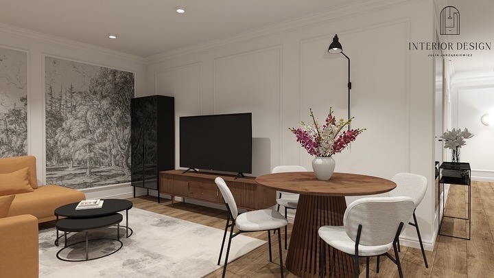 Wnętrze salonu z sofą w odcieniach pomarańczy, okrągłym stołem z kwiatami i telewizorem na tle ściany z dekoracyjnymi panelami. Całość w jasnej, stonowanej kolorystyce.