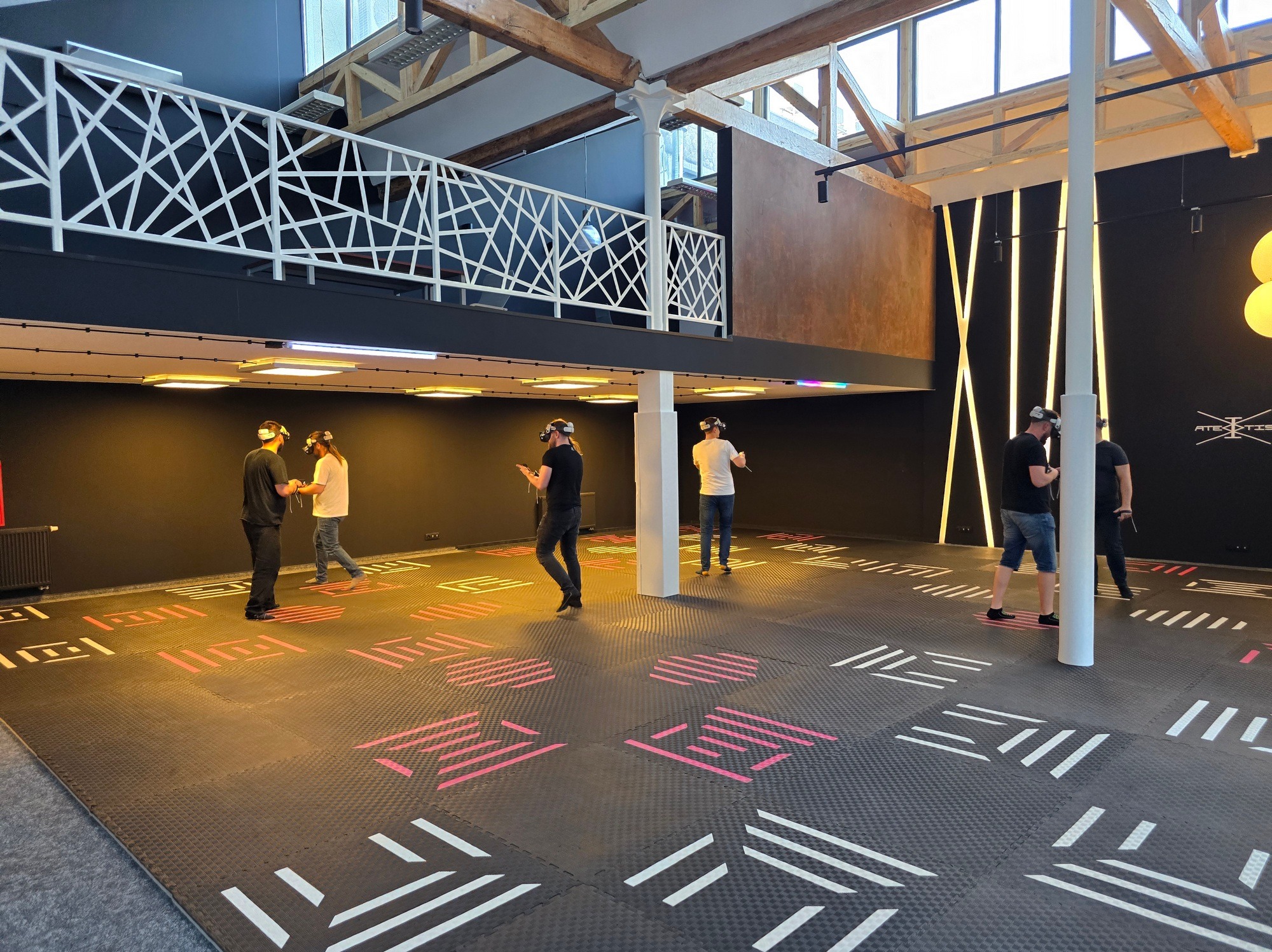 Uczestnicy w goglach VR w przestronnej sali z dekoracjami świetlnymi w Łodzi. Atrakcja na event firmowy zorganizowany przez agencję.