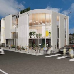 MAP Projekt - Wizualizacja dwukondygnacyjnego budynku biurowego z zaokrągloną fasadą i dużymi oknami, otoczonego zielenią i przechodniami na chodniku.