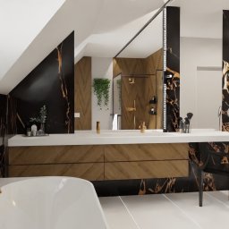 MAP Projekt - Elegancka łazienka na poddaszu z wanną, umywalką z drewnianą szafką i czarnymi panelami z żyłkami złota. W tle widoczny prysznic i dekoracyjne rośliny.