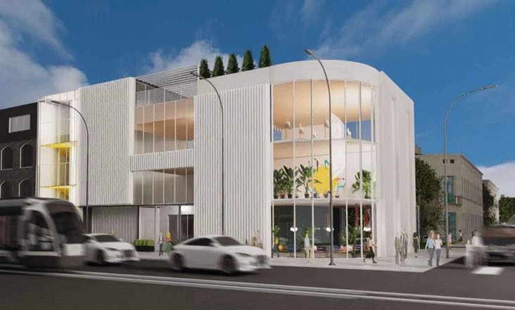 Wizualizacja nowoczesnego, białego budynku biurowego z dużymi oknami, roślinami wewnątrz i przejeżdżającym tramwajem. Budynek ma zaokrąglony narożnik i płaski dach.