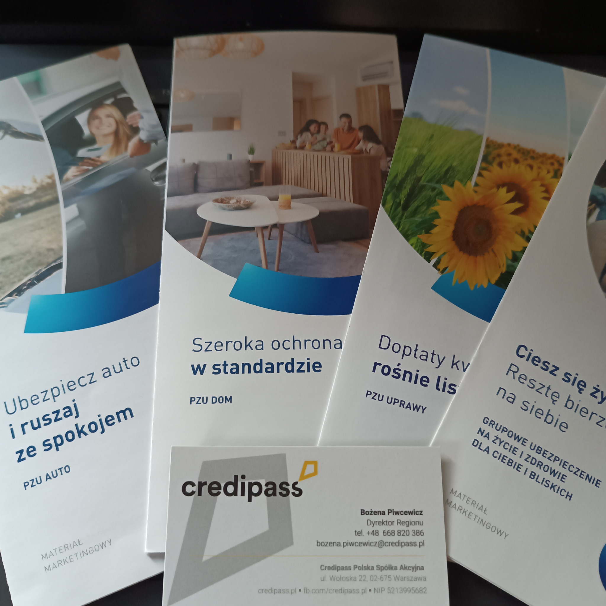 Materiały marketingowe PZU i Credipass: ulotki z ofertami ubezpieczeń (auto, dom, uprawy, życie) oraz wizytówka dyrektor regionu Credipass.
