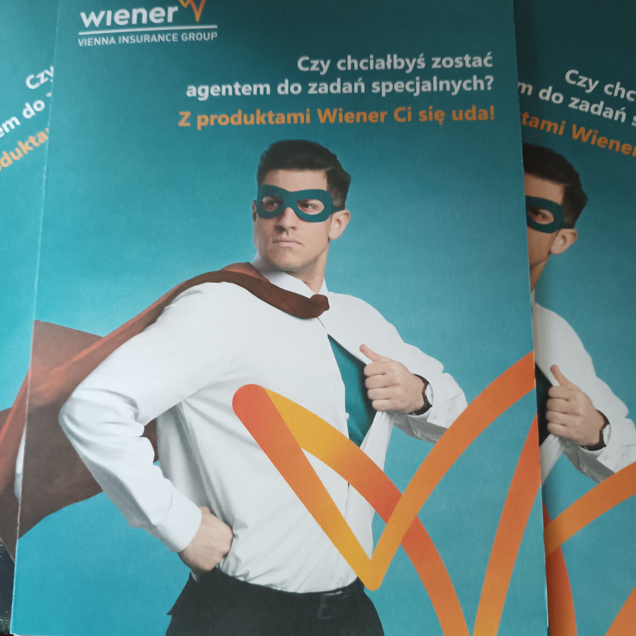 Ulotka reklamowa Wiener Insurance Group z wizerunkiem mężczyzny w masce superbohatera rozpinającego koszulę, hasło: Czy chciałbyś zostać agentem do zadań specjalnych? Z produktami Wiener Ci się uda!