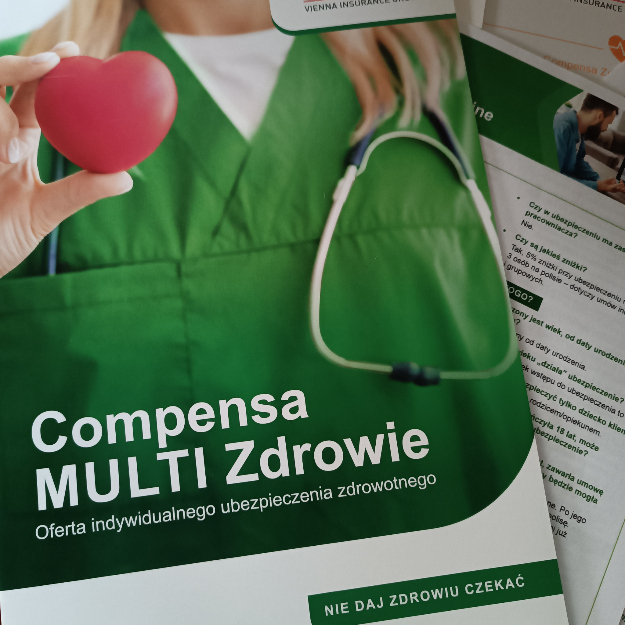 Ulotka informacyjna Compensa Multi Zdrowie z czerwonym sercem w dłoni, obok dokument z pytaniami dotyczącymi ubezpieczenia zdrowotnego.