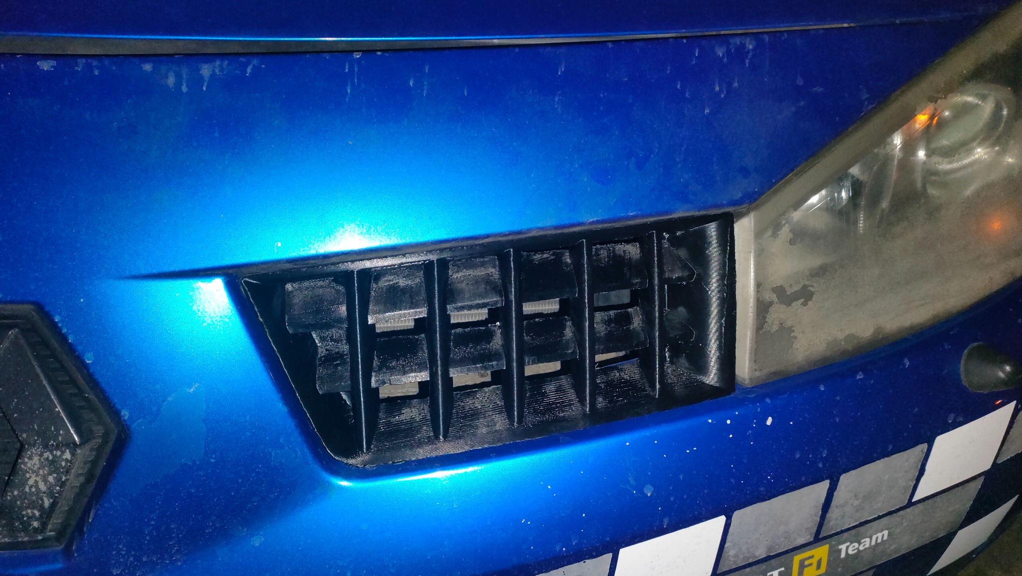 Czarny grill do Renault Megane RS, wydrukowany w technologii FDM z materiału ABS, zamontowany w niebieskim samochodzie. Usługa druku 3D w Gdańsku.