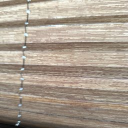 KRZYSZTOF MAZUR PROFIT PRZEDSIĘBIORSTWO BUDOWLANO-HANDLOWO-USŁUGOWE - Beżowe plisy okienne z delikatnym wzorem i sznurkiem sterującym, widoczne z bliska, z wyraźną fakturą materiału.