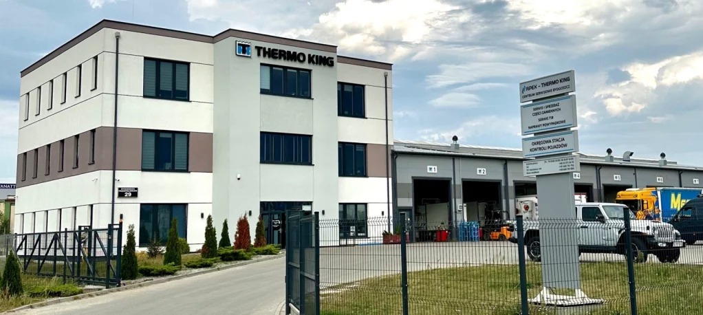 Budynek serwisu Thermo King z widocznym logo, tablicą informacyjną o usługach i zaparkowanymi pojazdami dostawczymi.