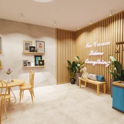 IWONA SADOWSKA F.H.U. STUDIO_ INSIDE - Wnętrze kawiarni w jasnych barwach z drewnianymi elementami, roślinami, stolikiem i napisem neonowym 'Ice Cream Solves Everything'.