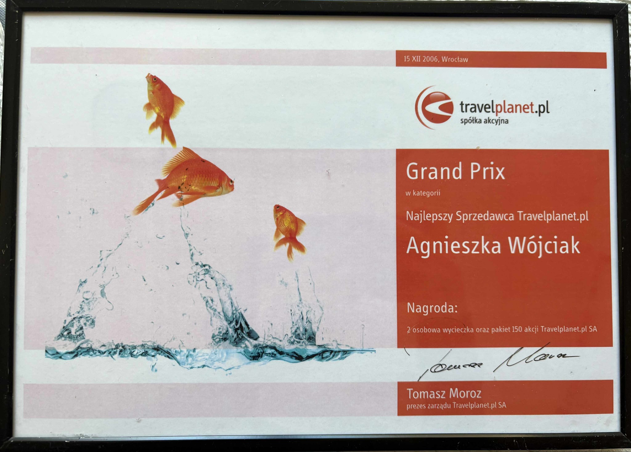 Oprawiony dyplom Travelplanet.pl dla Agnieszki Wójciak, Najlepszego Sprzedawcy, z grafiką złotych rybek i datą 15 XII 2006. Nagroda: wycieczka i akcje.