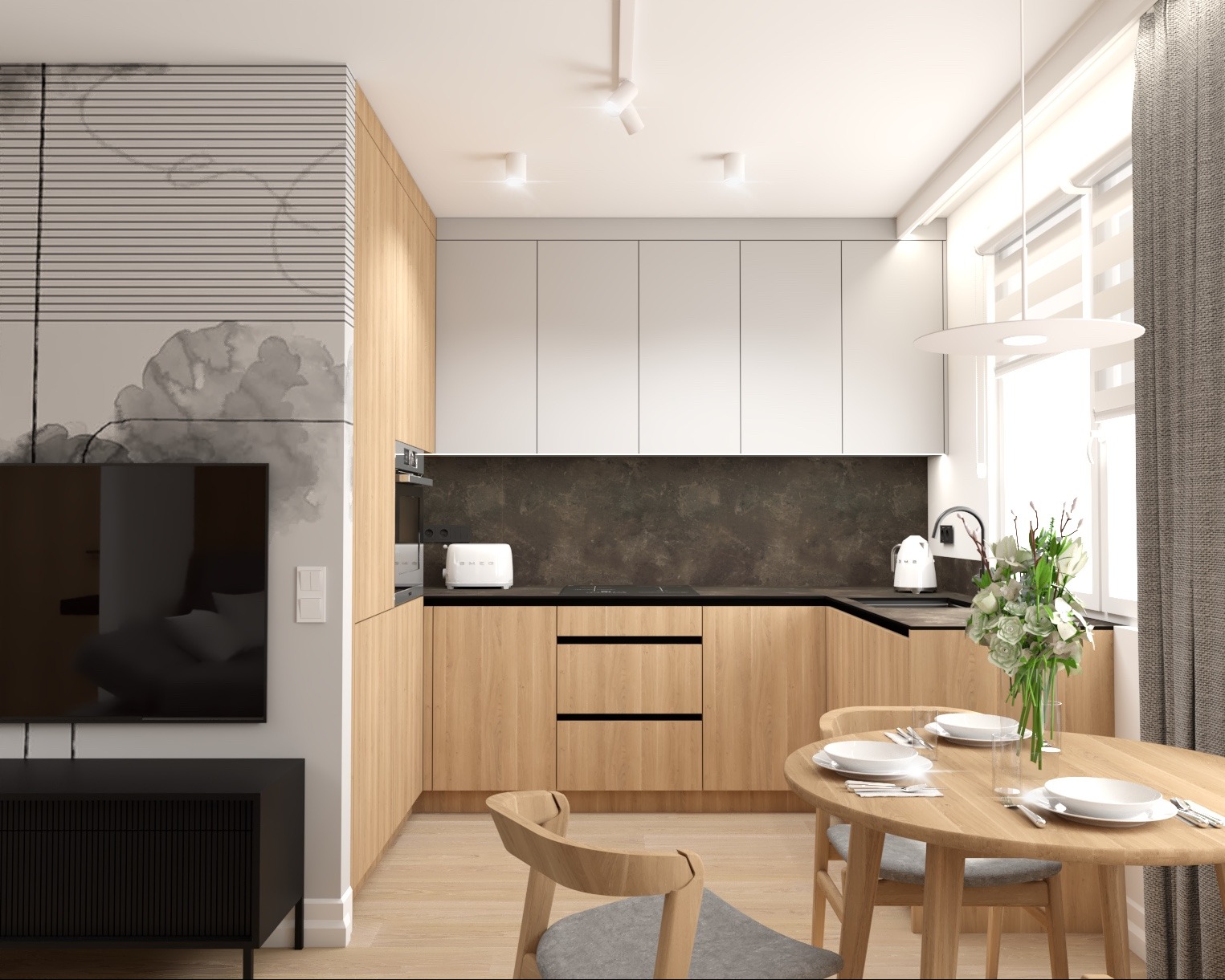 Jasne wnętrze kuchni z drewnianymi szafkami, białymi górnymi szafkami, okrągłym stołem z zastawą dla czterech osób i kwiatami w wazonie, akcentem jest ściana z abstrakcyjnym wzorem w odcieniach...