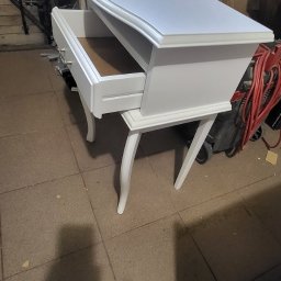 Ex-Mebel Marek Szpak - Biała toaletka w stylu Ludwika z wysuniętą szufladą, widoczne gięte nogi i frezowane krawędzie, tło warsztatowe.