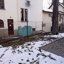 WANDZEL CUSTOM MICHAŁ WANDZEL - Ogrodzenie z siatki z widoczną zieloną bramką wejściową na posesję, zimowa sceneria z resztkami śniegu na trawniku.