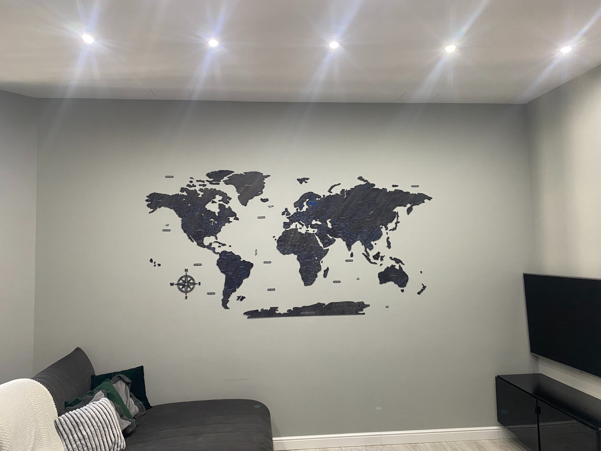 Ściany pomalowane w kolorze oraz montaż mapy świata z drewna na ścianie.