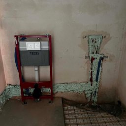 ADMAR INSTALACJE HYDRAULIKA - Montaż podtynkowej spłuczki TECE do WC, rury wod-kan w ścianie zabezpieczone pianką oraz ułożone rurki ogrzewania podłogowego.