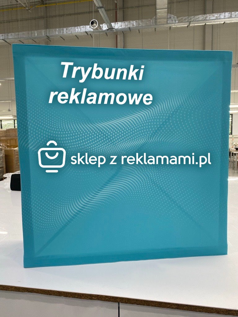 Niebieski trybunek reklamowy z białym napisem 'Trybunki reklamowe' i adresem strony internetowej, na tle hali produkcyjnej.