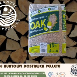 ATLANTIC AGRO PRODUKT SPÓŁKA Z OGRANICZONĄ ODPOWIEDZIALNOŚCIĄ - Worek z pelletem dębowym 6mm na tle drewna kominkowego. Opakowanie z certyfikatem ENplus A1, waga 15kg. Widoczne logo firmy Atlantic Agro Produkt.