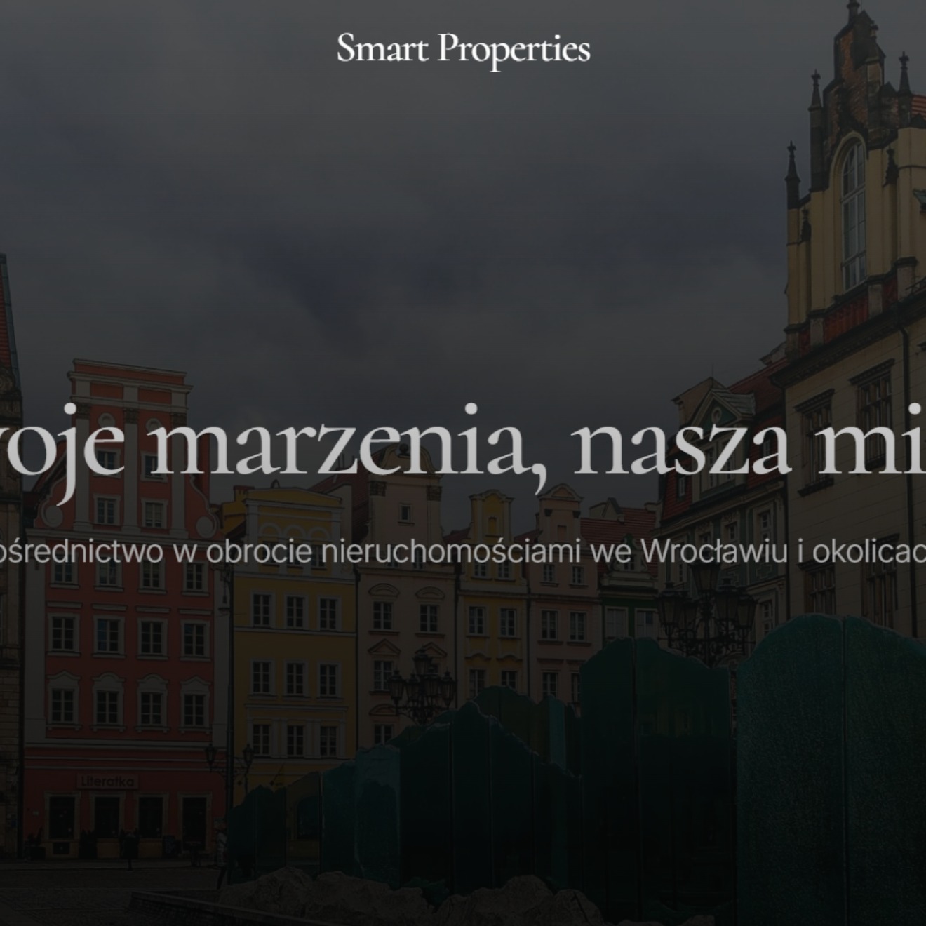 Strona internetowa firmy Smart Properties z widokiem na wrocławski rynek, tekst 'Twoje marzenia, nasza misja' na ciemnym tle.