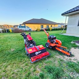 MM GardenTech Mateusz Gałek - Czerwona glebogryzarka i pomarańczowa mini-koparka rowów na trawniku przed domem, widoczne ślady użytkowania na trawie.