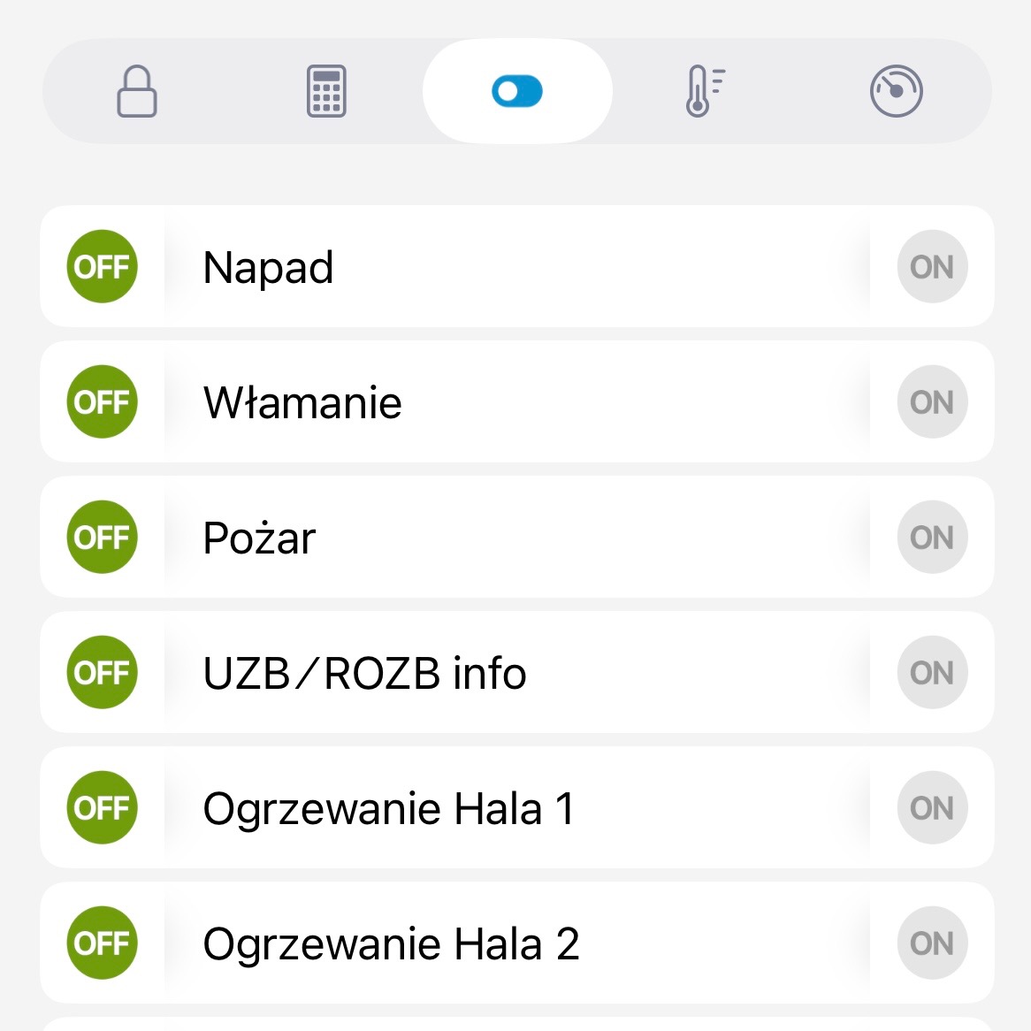 Ekran smartfona z aplikacją do zarządzania systemem inteligentnego domu, pokazujący status alarmów (napad, włamanie, pożar) i ogrzewania hal, z opcjami włączania i wyłączania.