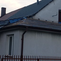 Kamil Woźniak - Dom w trakcie wymiany pokrycia dachowego, widoczne drewniane łaty i fragmenty nowej dachówki