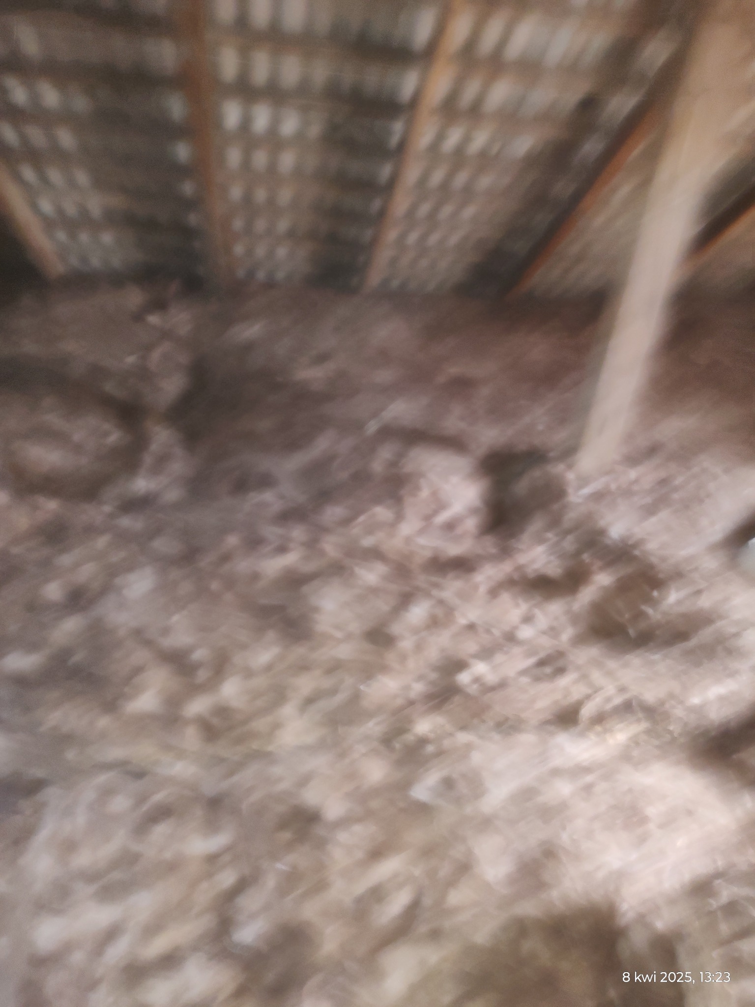 Niedokładne ujęcie wełny mineralnej na poddaszu, widoczne krokwie i poszycie dachu.