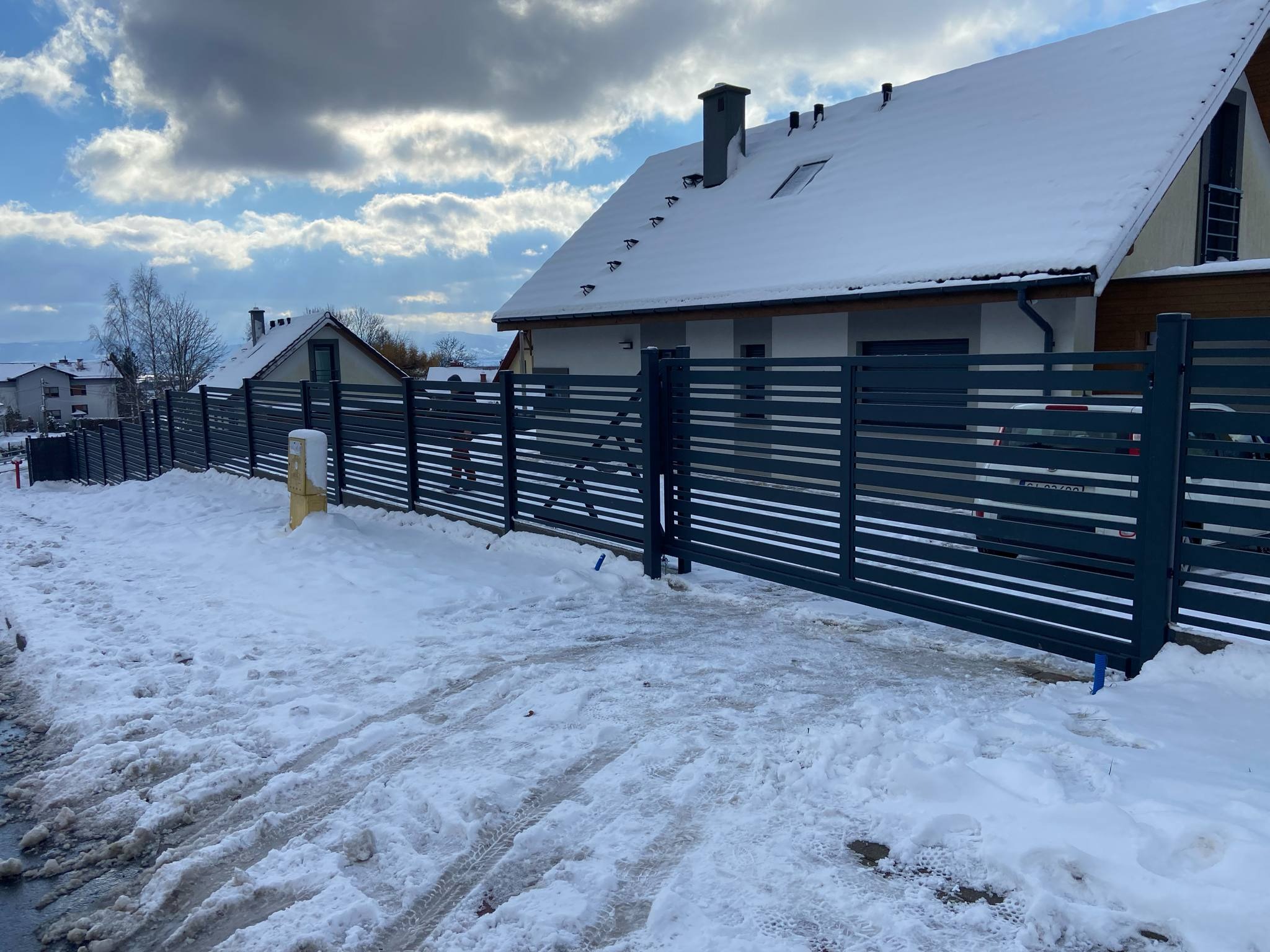 Nowoczesne, poziome ogrodzenie panelowe w kolorze antracytowym, zamontowane w Biernej. Śnieżny krajobraz podkreśla minimalistyczny design i solidność konstrukcji.