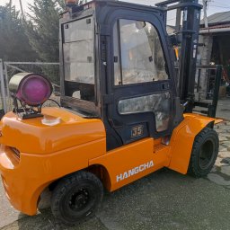 FHU MOBILTECHNIK TOMASZ KUBICA - Pomarańczowy wózek widłowy Hangcha z butlą gazową na zewnątrz, widoczne detale konstrukcyjne i oznaczenia modelu.